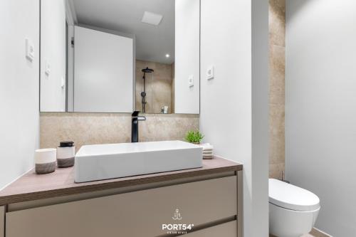 a bathroom with a white sink and a toilet at Sunrise Suite List auf Sylt in List