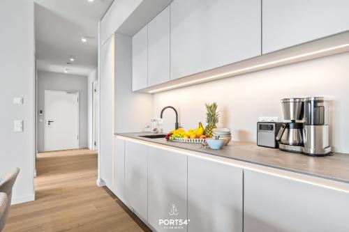 a kitchen with white cabinets and a bowl of fruit at Marina Suite List auf Sylt in List