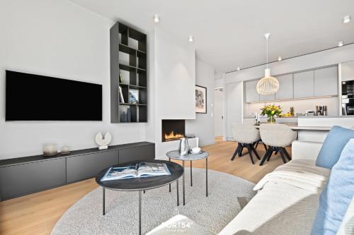 a living room with a couch and a tv at Marina Suite List auf Sylt in List