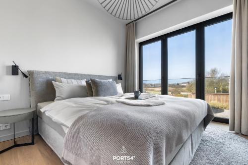 a bedroom with a large bed with a large window at Ocean Breeze Suite List auf Sylt in List