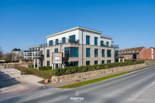 a large white building on the side of a road at Anchorage Suite List auf Sylt in List