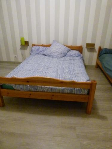 a bed with a wooden frame in a room at chambre proche circuit in Fillé