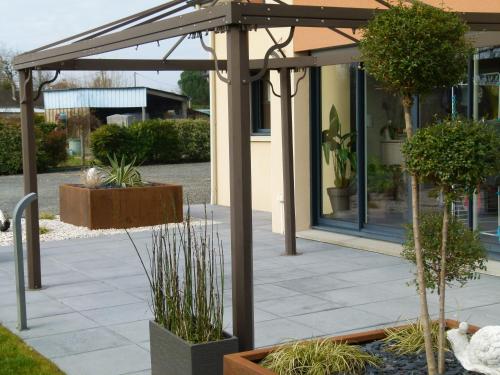 a patio with an umbrella and potted plants at chambre proche circuit in Fillé