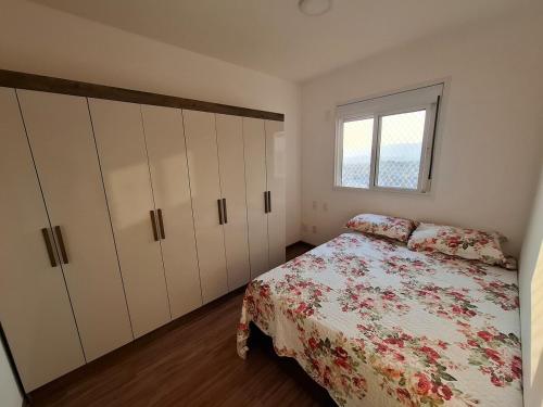 グアルーリョスにあるHigh standard APT next to Gru MAIA for 5 peopleのベッドルーム1室(ベッド1台、キャビネット、窓付)