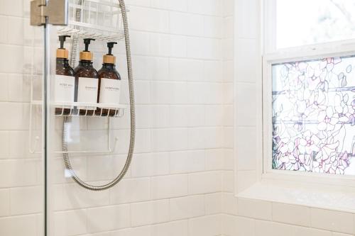 a shower with wine bottles on a shelf in a bathroom at Curly Sunshine Clearwater in Clearwater