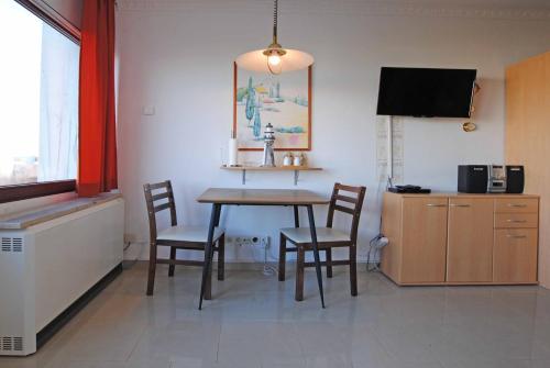 a dining room with a table and chairs and a tv at Ferienwohnung Thordsen 2 in Burgtiefe auf Fehmarn 