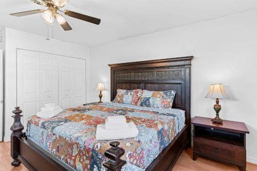 a bedroom with a bed and a ceiling fan at Curly Sunshine Clearwater in Clearwater