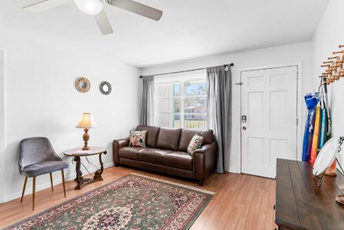 a living room with a leather couch and a table at Curly Sunshine Clearwater in Clearwater
