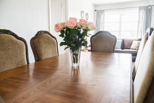 a vase of pink roses sitting on a wooden table at Curly Sunshine Clearwater in Clearwater