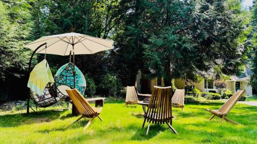 a group of chairs and an umbrella in the grass at Joy House in Woodinville