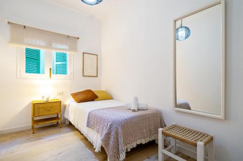 a bedroom with a bed and a table and a window at Apartamento Ses Botges - Formentera Break in Es Calo