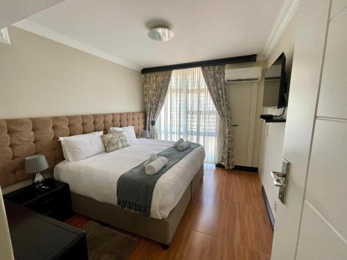 a bedroom with a large bed with a large window at Durban Suites at Oceanic in Durban