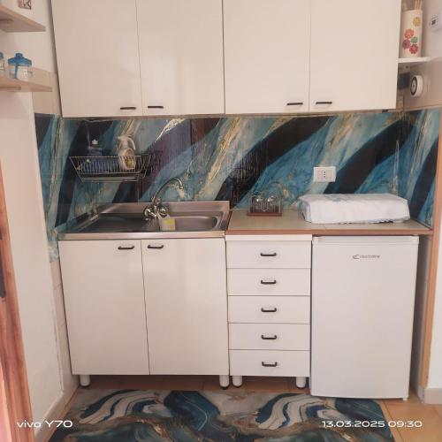 a kitchen with white cabinets and a sink at Casa Vacanza Il Pontile Mini Appartamento in Cipollina