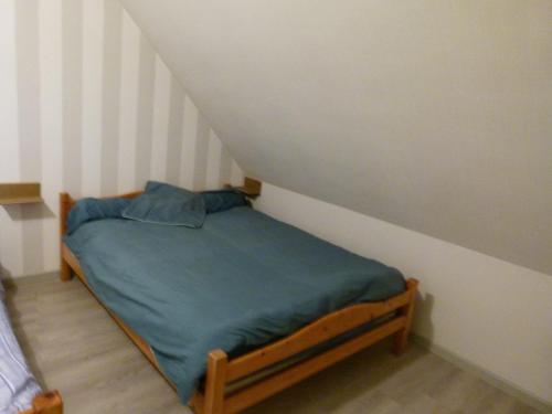 a small bedroom with a bed in a attic at chambre proche circuit in Fillé
