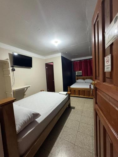 a hotel room with two beds and a tv at Panamá Hostels Inn in David