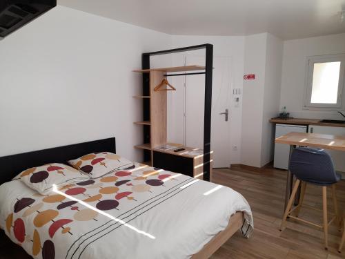 a bedroom with a bed and a table and a desk at CHARMANT STUDIO DANS UNE MAISON NEUVE in La Roche-sur-Yon