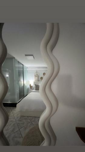 a bedroom with a white bed and a room with a bed sqor at Himalayas in Gjirokastër