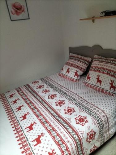 - un lit avec une couverture et des oreillers rouges et blancs dans l'établissement T3 Duplex Les Marmottes, à Le Mont-Dore