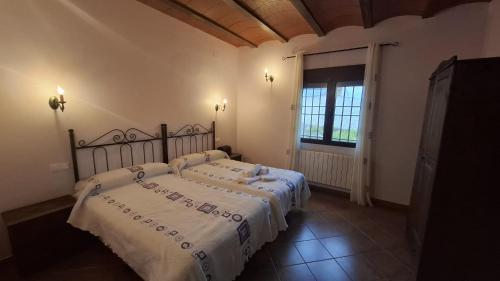 a bedroom with two beds with white sheets and a window at VENTA DE LA SISA in Sisante