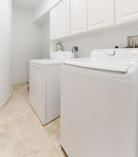a white laundry room with a washer and dryer at Beachside Luxury Private Townhome with Pool and Ocean Views in Boca Raton