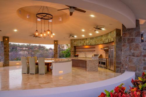 an open kitchen and dining room with a stone wall at Spacious 5 Bd Villa Fully Staffed w Chauffeur in Puerto Los Cabos! in San José del Cabo