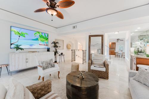 a living room with a ceiling fan and a table at Beachside Luxury Private Townhome with Pool and Ocean Views in Boca Raton