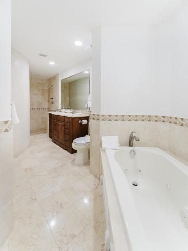a large bathroom with a tub and a toilet at Beachside Luxury Private Townhome with Pool and Ocean Views in Boca Raton