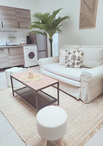 un salon avec un canapé et une table dans l'établissement Le Cocon Palmier, à Vitré