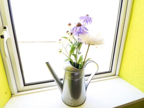 a vase with flowers sitting on a window sill at Sugarbush in Eyeries