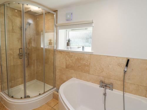 a bathroom with a shower and a bath tub at Waters Edge in Alnwick