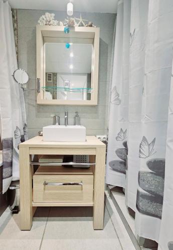 une salle de bain avec un lavabo et un miroir dans l'établissement SUPERBE STUDIO DANS CADRE D'EXCEPTION-PISCINE, TENNIS et PLAGE PRIVEE, à Bandol