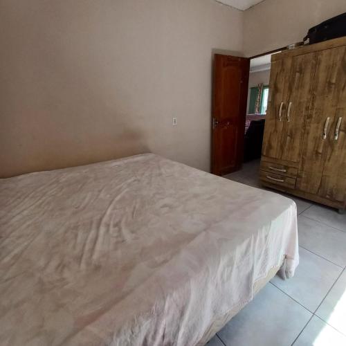 a bedroom with a bed and a wooden cabinet at COP30 Casa Completa in Barcarena