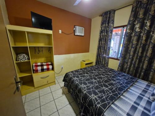 a bedroom with a bed and a tv in it at Aeropouso Pousada Executiva in Florianópolis