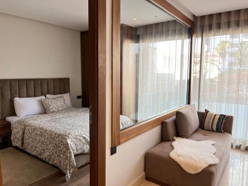 ein Schlafzimmer mit einem Bett, einem Spiegel und einem Stuhl in der Unterkunft Signature Leving 119 in Casablanca