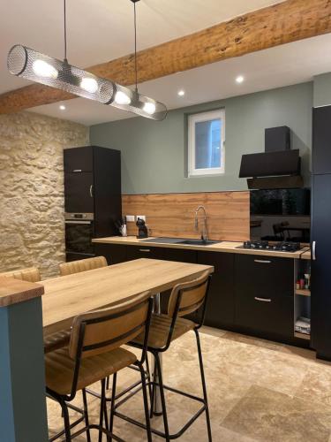 une cuisine avec une table et des chaises en bois dans l'établissement Maison du soleil, à Caumont-sur-Durance