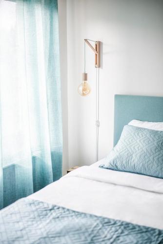 a bedroom with a bed and a blue curtain at Chalupa Libverda in Lázně Libverda