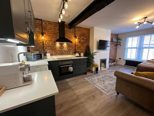 a kitchen and living room with a brick wall at Urban Chic- Stylish Flat in the Heart of St Albans in St. Albans
