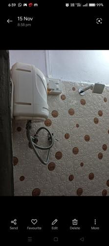 a bathroom with a toilet and a polka dot floor at ब्रम्हांडनायक गेस्ट हाऊस in Akalkot
