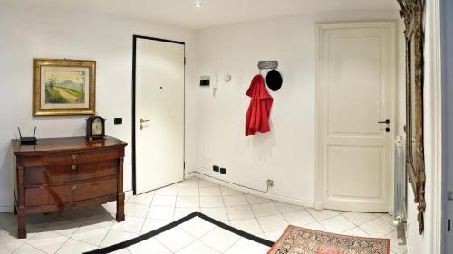 ein Zimmer mit einer Kommode und einer Tür mit einem roten Pullover drauf in der Unterkunft Romeo Apartments in Santa Margherita Ligure