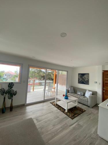 a living room with a couch and a table at Ibiza-Modern apartment steps from the beach in Ayampe