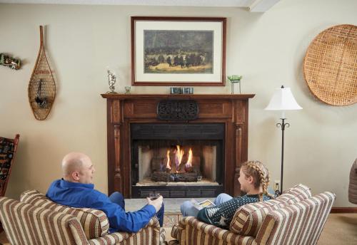 a man and a woman sitting in front of a fireplace at Rippling Waters close to Timberline ski slopes in Cortland