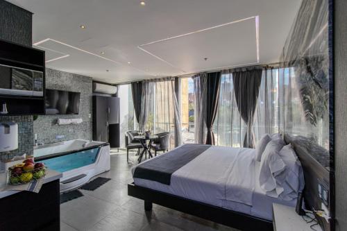a bedroom with a large bed and a tub in a room at Haven, A Design Hotel in Medellín