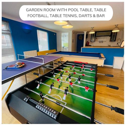 a ping pong room with pool tables and avertisement at Big groups XL HotTub Cinema Arcade Games in Stonehouse