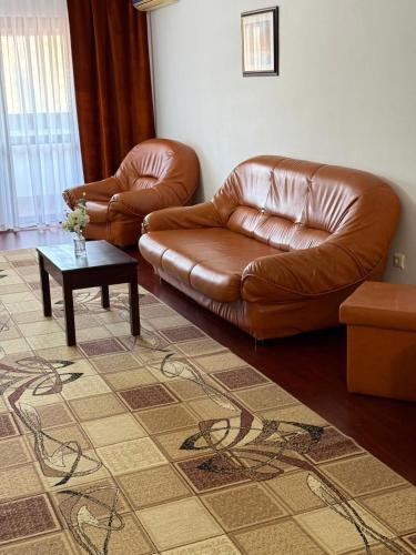 a living room with a leather couch and a coffee table at Hotel Ciric in Iaşi