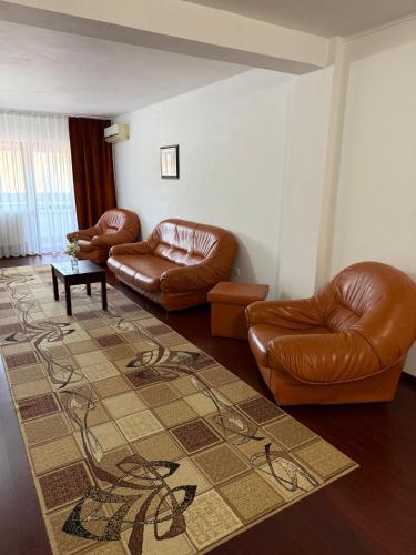 a living room with two leather couches and a rug at Hotel Ciric in Iaşi