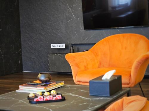 - un salon avec une chaise et une table avec une télévision dans l'établissement Lavish Apartment, à Dej