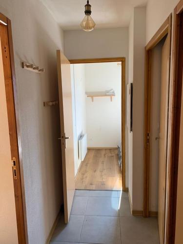 un couloir avec une porte menant à une chambre dans l'établissement Appartement ignaux, à Ignaux