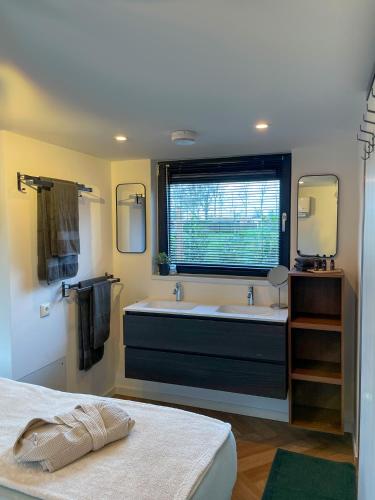 a bathroom with a large tub and a sink at Lobsters Lodge in Heinkenszand ' Wellness Accommodation with Wood-Fired Hottub, Private Sauna and Outdoor Shower ' Airco's ' Free Wifi ' Complimentary Bed linen and Towels in Heinkensand