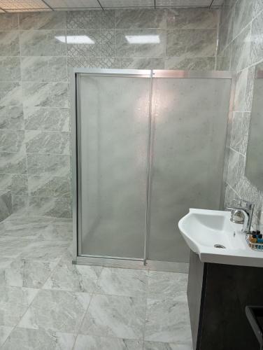 a bathroom with a shower and a white sink at Aslan Guest House in Sanlıurfa