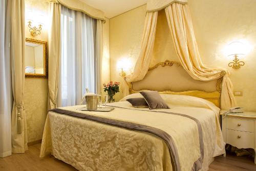 Un dormitorio con una cama grande con dosel. en Residenza Goldoni, en Venecia